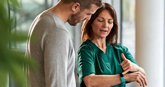 female-medic-demonstrating-wrist-device-to-patient