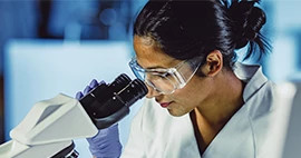 female-medical-professional-looking-through-microscope