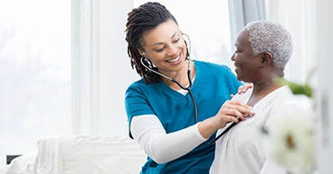young-female-medic-performing-check-up-on-female-patient young-female-medic-performing-check-up-on-female-patient